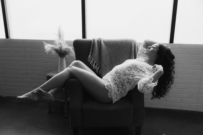 woman laying across chair with crochet shirt